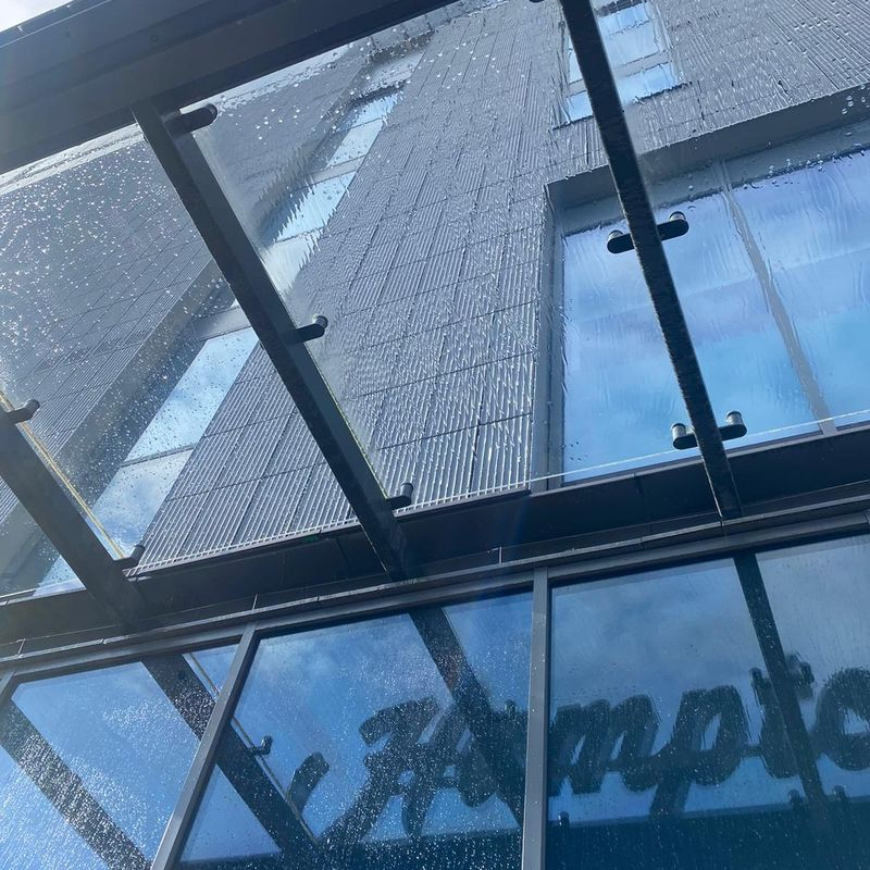 A glass hotel canopy during a Trojan FM clean