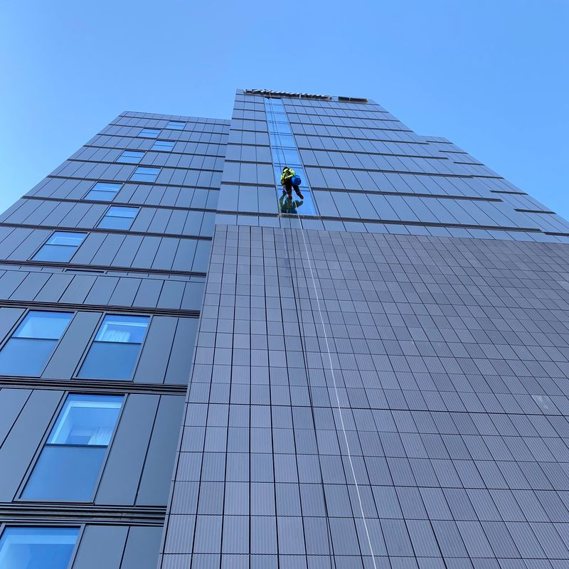 Trojan FM staff member cleaning a high rise window